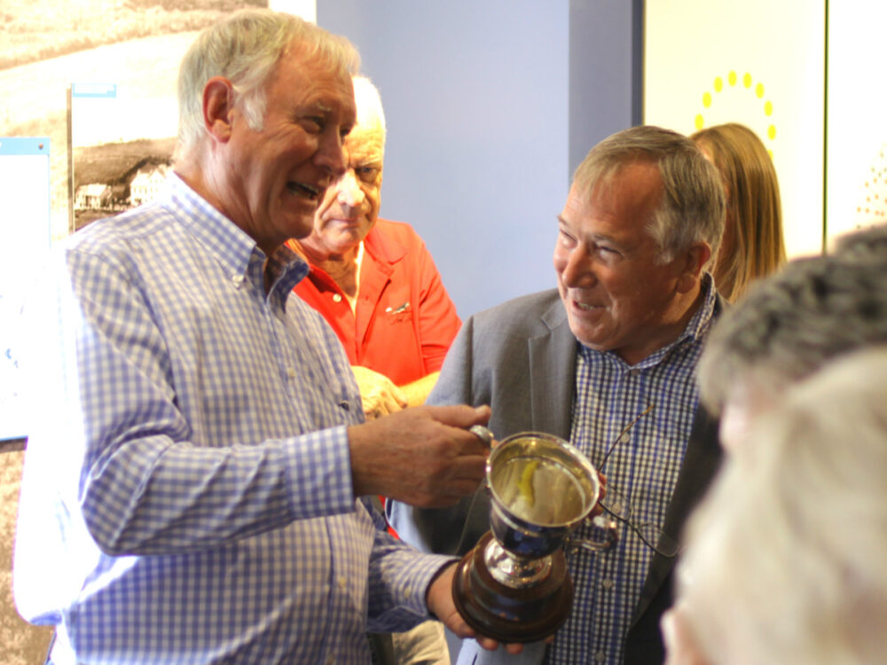 Photograph of Peter Burleigh and Gareth Parry enjoying a friendly conversation about the Exiles Golf Society Trophy.